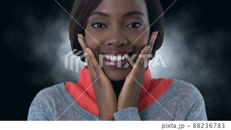 African american businesswoman smiling with hands on her chin against copy space on black background 88236783