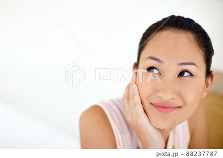 What can I do today. Shot of a beautiful young woman enjoying a thoughtful moment to herself. 88237787