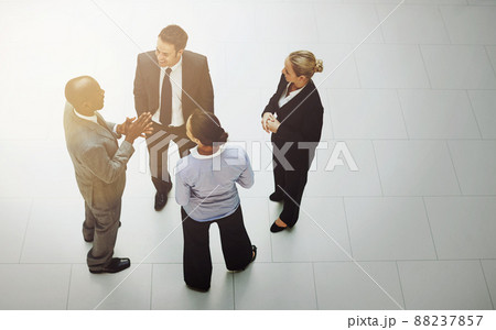 Office chatter. High angle shot of a group of businesspeople talking in the office lobby. Office chatter. High angle shot of a group of businesspeople talking in the office lobby. 88237857