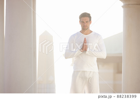 Starting the day in peace. Three quarter shot of a young man doing yoga outdoors. Starting the day in peace. Three quarter shot of a young man doing yoga outdoors. 88238399