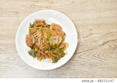 spicy stir fried glass noodles with pickled bamboo and mixed vegetable couple pork Thai northern style food called Pad Hor on plate 88253147