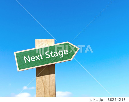 NextStageの文字入り緑色の道しるべと青空_右空間 88254213