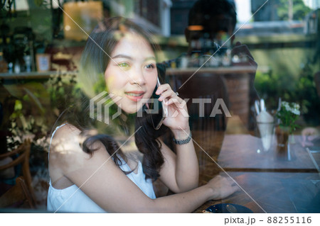 Beautiful asian women use smartphone drinking coffe in cafe 88255116