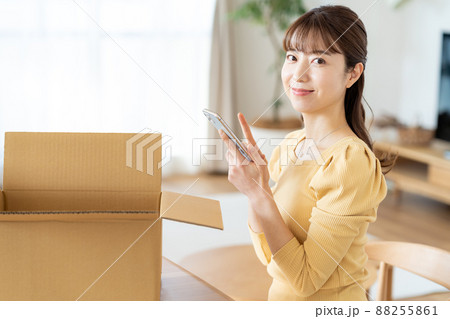 リビングで段ボールに荷造りする女性 88255861