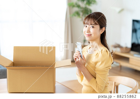 リビングで段ボールに荷造りする女性 88255862