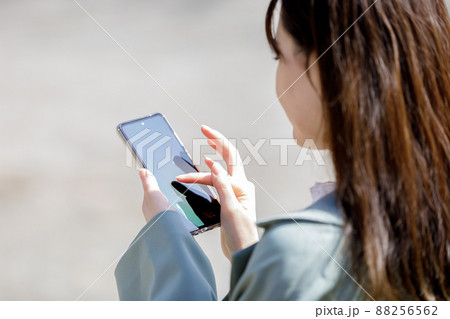 スマホを操作する女性の手元 88256562