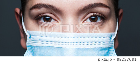 Young caucasian woman wearing blue surgical face mask closeup wide screen portrait 88257681