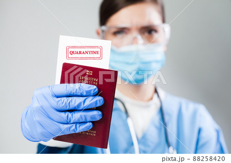 Doctor or nurse at airport customs security check holding a passport Doctor or nurse at airport customs security check holding a passport 88258420