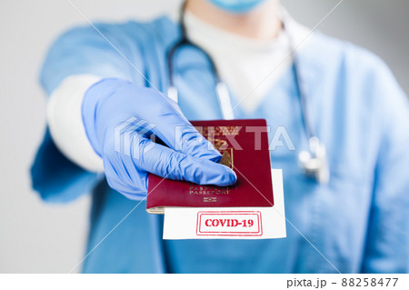 Doctor handing over immunity passport Doctor handing over immunity passport 88258477