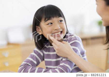 母親に歯を見せる女の子 88261221