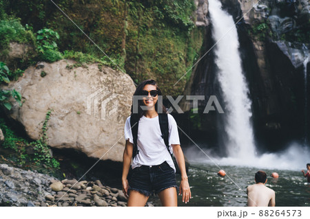 Smiling tourist spending holidays in mountain terrain with waterfall 88264573