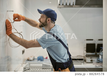 Joyful male worker turning bolt with wrench Joyful male worker turning bolt with wrench 88264578