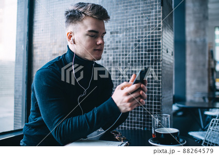 Thoughtful man text messaging in cafe 88264579
