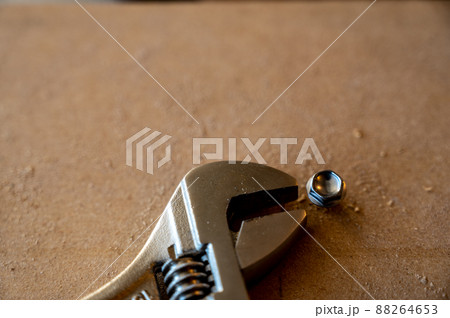 rounded stuck bolt head next to a crescent wrench 88264653