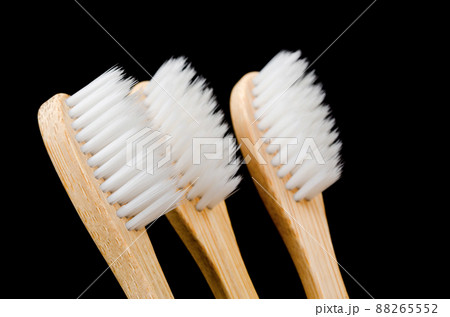 Bamboo toothbrushes in wooden cup on black background, Zero waste concept. Bamboo toothbrushes in wooden cup on black background, Zero waste concept. 88265552