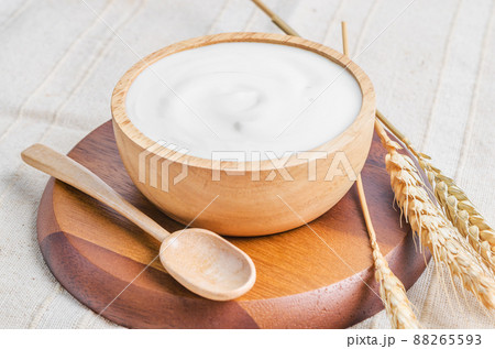 Greek yogurt in a wooden bowl and dry barley on tablecloth. Greek yogurt in a wooden bowl and dry barley on tablecloth. 88265593