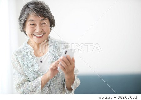 スマホを見るシニアの女性　 88265653