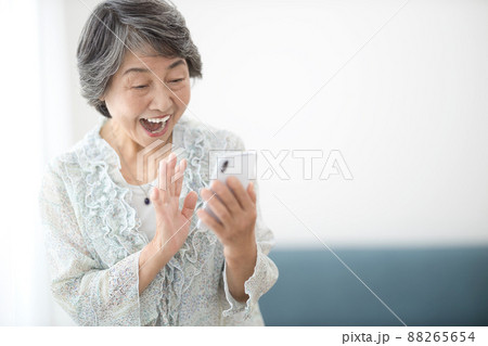 スマホを見るシニアの女性　 88265654