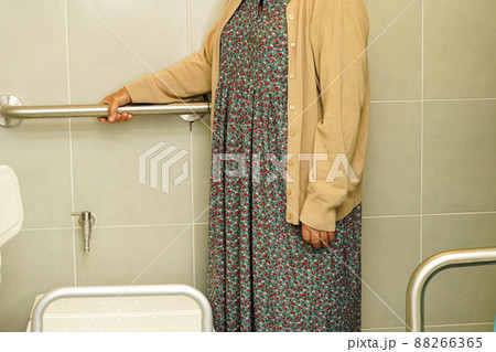Asian elderly old woman patient use toilet support rail in bathroom, handrail safety grab bar, security in nursing hospital. Asian elderly old woman patient use toilet support rail in bathroom, handrail safety grab bar, security in nursing hospital. 88266365