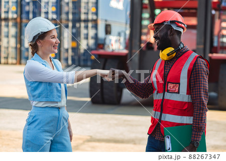 Businesswoman and engineer join hands to work success loading Containers box from Cargo freight ship for import export. Freight containers in sea port. Businesswoman and engineer join hands to work success loading Containers box from Cargo freight ship for import export. Freight containers in sea port. 88267347