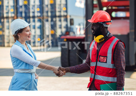 Happy dealing shaking hands two businesswoman and engineer working checking loading Containers box from Cargo freight ship for import export. shipping in docks. 88267351