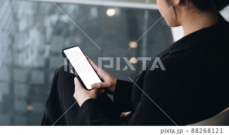 Businesswoman holding smart phone with white blank screen. For Graphic display montage 88268121