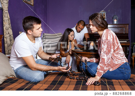 Young people with wooden rosary in escape room 88268868