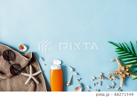 Beach accessories on pastel blue background top view. Summer background. 88271549