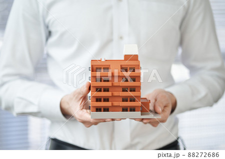 マンションの建築模型を持つアジア人男性の手元 88272686