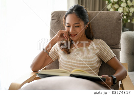 Relaxed Asian woman enjoy reading her favorite novel or book 88274317