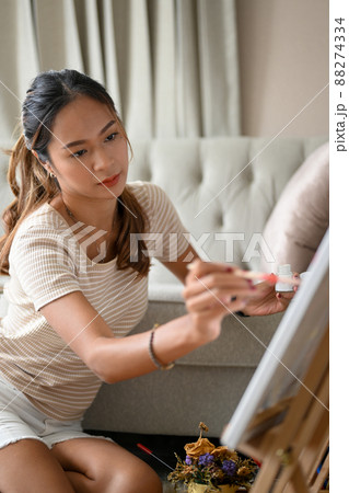 Attractive and charming Asian woman focused painting her artwork 88274334