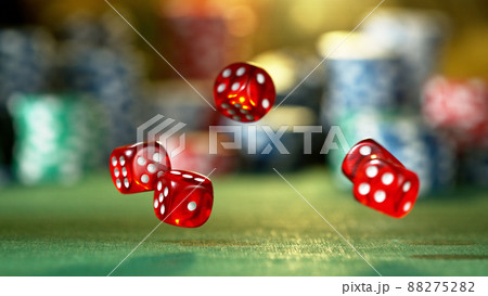 Red dice rotating in the air, poker chips on background. 88275282