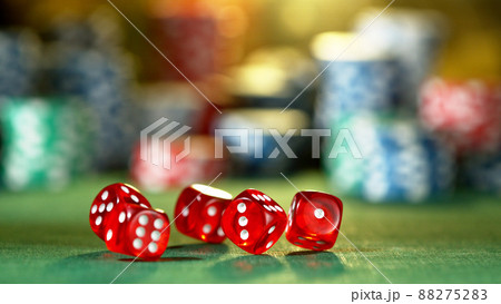 Red dice rotating in the air, poker chips on background. 88275283
