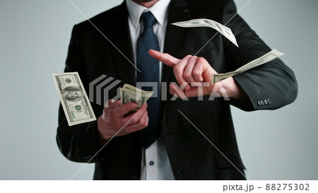 Close-up of a young businessman throwing out money banknotes Close-up of a young businessman throwing out money banknotes 88275302