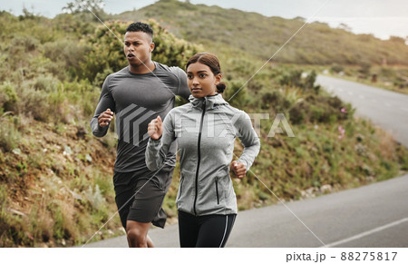 Dont stop until you reach the end. Shot of two sporty young people running outdoors. Dont stop until you reach the end. Shot of two sporty young people running outdoors. 88275817