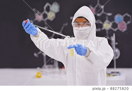 Caution in the lab. A young scientist in protective clothing using a pipet in her lab. Caution in the lab. A young scientist in protective clothing using a pipet in her lab. 88275820