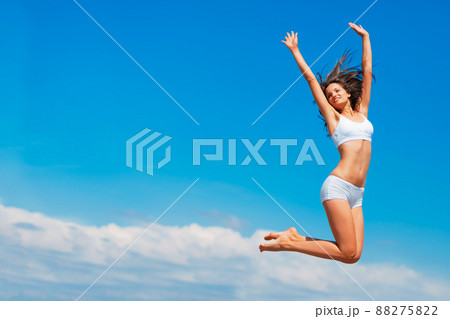 Happy the higher I go. Shot of a happy young woman jumping high in the sky. 88275822