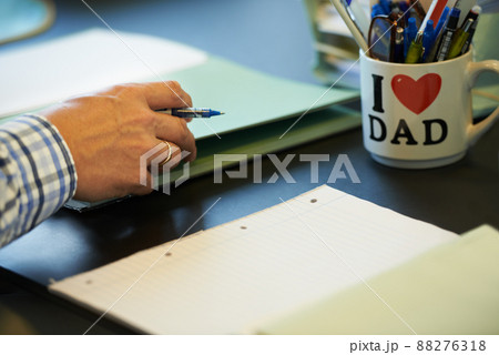 He takes pride in his workspace. Cropped image of a businessman sitting at his office desk with paperwork and stationary in front of him. He takes pride in his workspace. Cropped image of a businessman sitting at his office desk with paperwork and stationary in front of him. 88276318