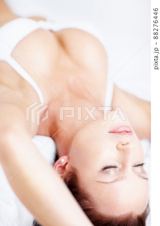 Young busty woman lying relaxed in bed. Relaxed sensuous woman lying on bed in lingerie. Young busty woman lying relaxed in bed. Relaxed sensuous woman lying on bed in lingerie. 88276446