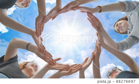 Friends make a circle with their palms against the blue sky. Friends make a circle with their palms against the blue sky. 88276697
