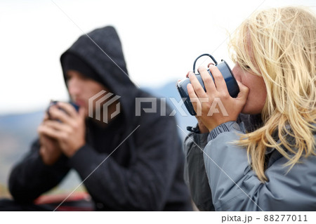 Taking a coffee break. A young couple taking a coffee break while on their hike together. 88277011