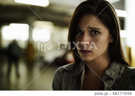 Feeling a twinge of fear. A terrified young woman in an underground parking garage being followed by a sinister man. Feeling a twinge of fear. A terrified young woman in an underground parking garage being followed by a sinister man. 88277048