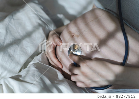 Pregnant woman listens to the baby heartbeat and movements with a stethoscope or fetoscope or Pinard Horn. Prenatal fetal health, anxiety, fear concept Pregnant woman listens to the baby heartbeat and movements with a stethoscope or fetoscope or Pinard Horn. Prenatal fetal health, anxiety, fear concept 88277915
