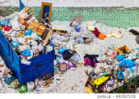 Household waste in trash can covered by snow in rural in winter. 88282528