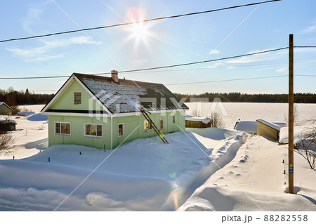 Northern latitudes during winter in village with rural buildings and snowdrifts. 88282558