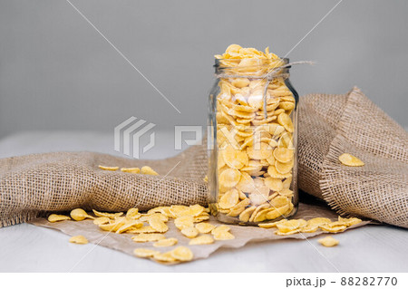 Corn flakes in a glass jar on white wooden surface. Place for your text Corn flakes in a glass jar on white wooden surface. Place for your text 88282770