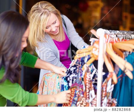 Raiding the sale rack. Two young woman looking through the sale items in a store together. Raiding the sale rack. Two young woman looking through the sale items in a store together. 88282868