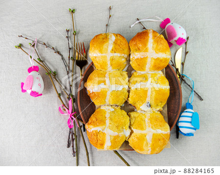 Hot cross buns on plate linen cloth Easter eggs table top view. Traditional sweet pastry. Christian holidays Good Friday Hot cross buns on plate linen cloth Easter eggs table top view. Traditional sweet pastry. Christian holidays Good Friday 88284165