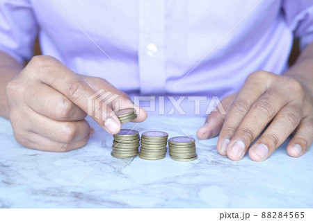 man's Hand putting stack of coins 88284565