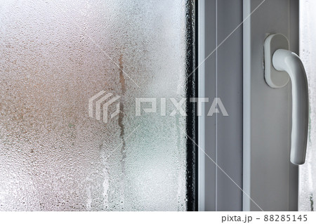 Glass of window with condensation, natural water drops on glass, high humidity. Blurred. 88285145